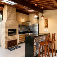 Área gourmet com balcão em granito e churrasqueira da Decorativa Mármores e Granitos no Jardim Jockey Club em Cu