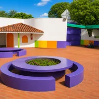Patio interno com jardim circular e bancos roxos da Escola Manoel de Barros na Vila Almeida Lima em Campo Grande