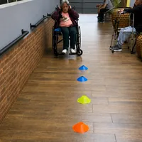 Idosa em cadeira de rodas participando de atividade com cones no CEI - Centro Especializado para Idosos no Monte
