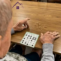 Idoso jogando bingo com cartela e marcadores no CEI - Centro Especializado para Idosos no Monte Castelo em Campo